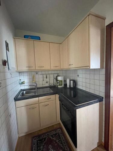 a small kitchen with a sink and a stove at Vier Jahreszeiten 4JZ Haus 1 Whg 71 in Großenbrode
