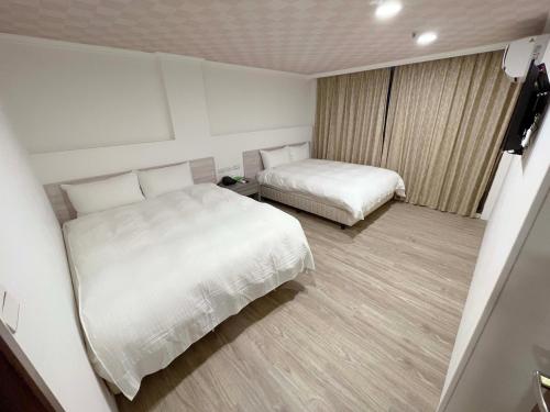 a hotel room with two beds and a window at Su Ao Hotel in Suao
