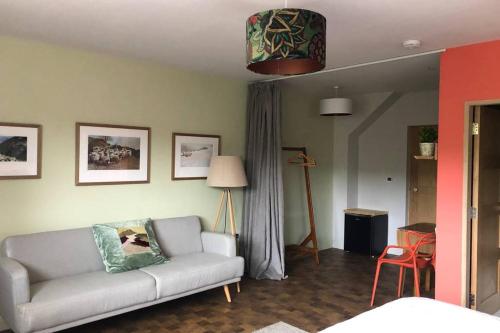 ein Wohnzimmer mit einem Sofa und einer Lampe in der Unterkunft "The Studio" Contemporary studio with organic swimming pool in Skelsmergh