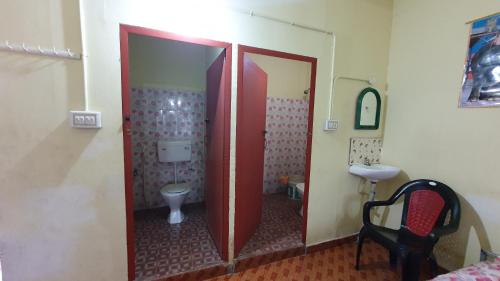a bathroom with two doors and a toilet at Ashavis Hotel Pvt Ltd in Māvelikara