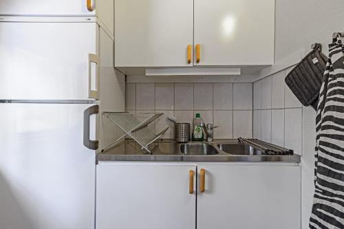 uma cozinha com armários brancos e um lavatório em Gilleråsvägen 13 B em Sälen