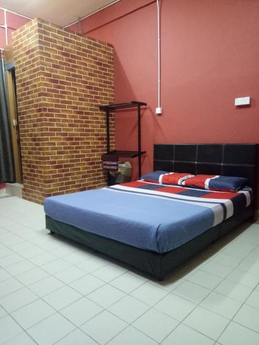 a bed in a room with a brick wall at KUALA BESUT JETTY BUDGET HOTEL AIN - In front of Kuala Besut Jetty in Kampung Kuala Besut