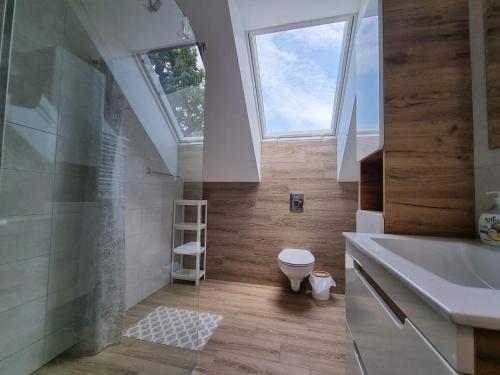 a bathroom with a toilet and a sink and a skylight at Willa Słoneczna in Sztutowo