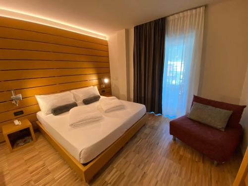 a bedroom with a large bed and a chair at Lake Front Hotel Mirage in Riva del Garda