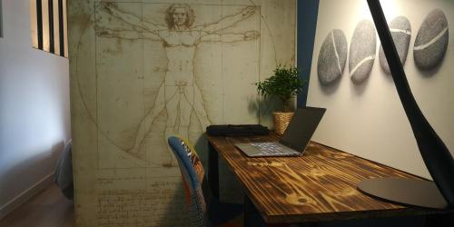 a laptop sitting on a wooden table in a room at Moderne et paisible studio avec balcon in Saint-Avold