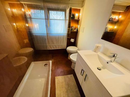 ein Badezimmer mit einem Waschbecken, einem WC und einer Badewanne in der Unterkunft Matilde House in Fregene