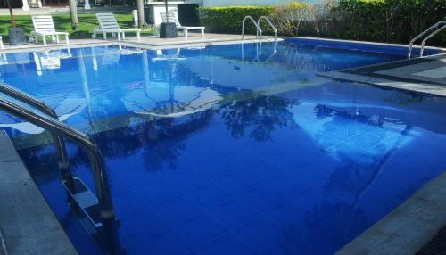 a large blue swimming pool with two chairs in it at NEW SITHI VILLAS in Hikkaduwa