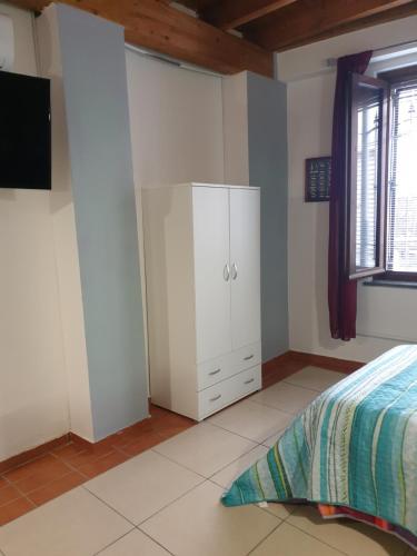 a bedroom with a white cabinet and a bed at ROMEO2 in Somma Lombardo