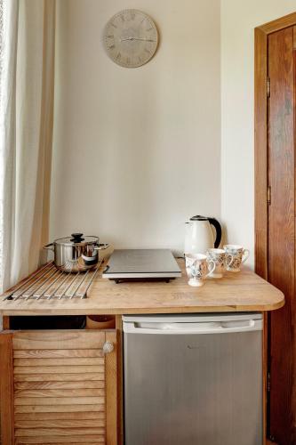 a kitchen with a counter with a laptop and a clock at Apartamenty Szwarcowa in Tylicz