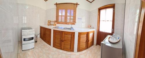 a kitchen with a sink and a stove at Chez Lester in Baie Sainte Anne