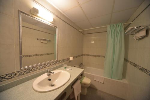 a bathroom with a sink and a toilet and a mirror at BLUESEA Copacabana in Lloret de Mar