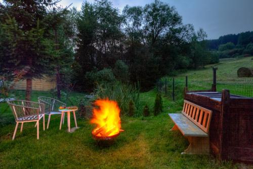 a fire pit in a yard next to a bench at Apartamenty Szwarcowa in Tylicz