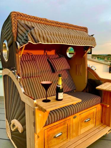 a chair with a bottle of wine and a wine glass at Penthouse mit Dachterrasse, Meerblick, Gasgrill, Klimaanlage, Kamin, Luxus-Design-Apartment, 2 Minuten zum Strand in Binz