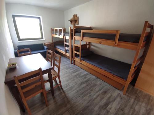 Zimmer mit 3 Etagenbetten sowie einem Tisch und Stühlen in der Unterkunft 2-bedroom holiday home in Park Istra in Koper