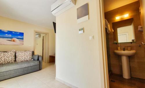 ein Bad mit einem Sofa und einem Waschbecken in einem Zimmer in der Unterkunft Astra Sarti Luxury Suites in Sarti