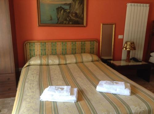 a bedroom with a bed with two towels on it at Villa Le Logge in Ventimiglia
