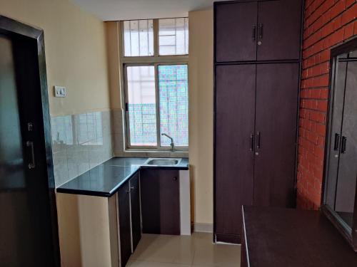 a kitchen with a sink and a window at Fernandes Complex in Bangalore