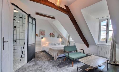 a bedroom with a bed and a chair at Artefact in Lamballe