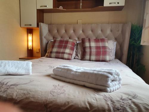 a bed with two towels on top of it at Clwyd 6 in Borth