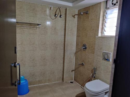 a bathroom with a shower and a toilet at Fernandes Complex in Bangalore