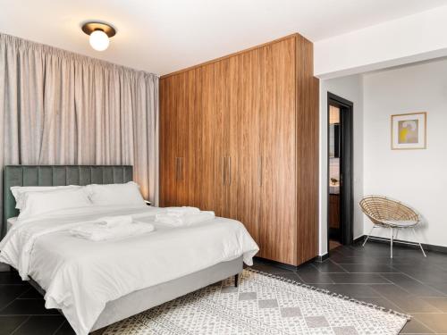 um quarto com uma cama grande e um armário de madeira em LIV URBAN Suites em Lárnaca