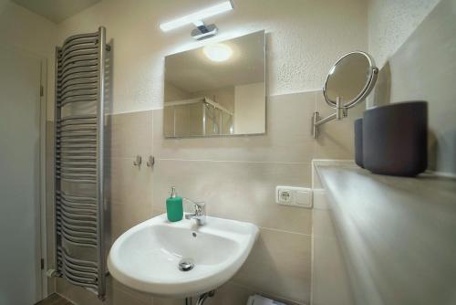 ein Badezimmer mit Waschbecken und Spiegel in der Unterkunft Bungalow am Neustädter See in Neustadt-Glewe