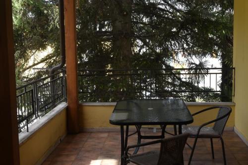 un tavolo nero e sedie su un balcone con un albero di Cospea B&B a Terni