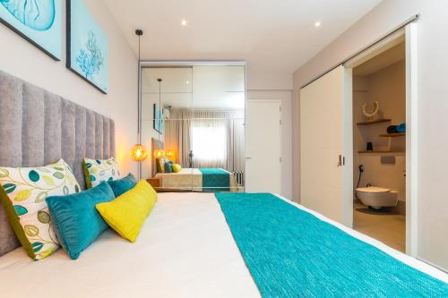 a bedroom with a large bed with blue and yellow pillows at ONE BAY RESIDENCE NO 8 in Grand Baie