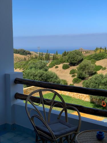 a chair sitting on a balcony looking out at the ocean at Dmina House in Asilah