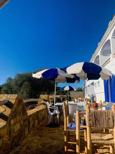 a table and chairs with umbrellas on a patio at Dmina House in Asilah