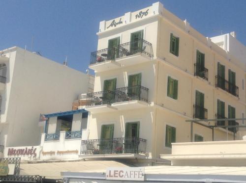 a white building with balconies on the side of it at Aegli 1876 in Tinos Town