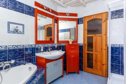 y baño con bañera, lavabo y espejo. en Penzión Javor - apartmány, en Ždiar