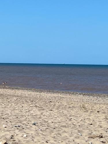 a sandy beach with the ocean in the background at Cosy caravan in Hull
