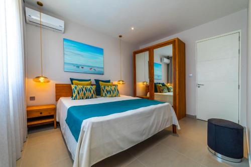 Un dormitorio con una cama azul y blanca y un espejo en ONE BAY RESIDENCE NO 8, en Grand Baie