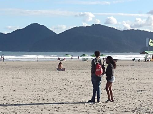 a man and a woman standing on a beach at Hotel e Pousada das Goianas in Santos