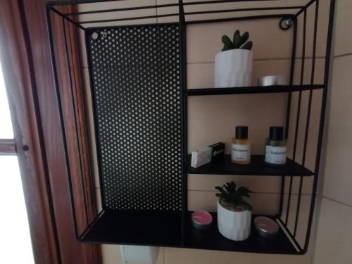 a black shelf with bottles and plants on it at MON Accommodation free parking in Niš