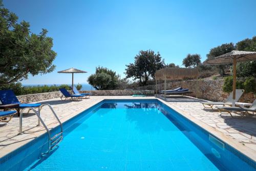 a swimming pool with blue water in a villa at Astra Villas in Skala Kefalonias