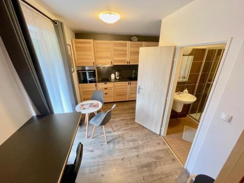諾瓦佩茲的住宿－Apartmán u jezera Lipno - Nové，带桌椅的厨房和浴室