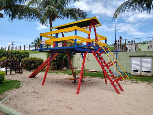 un parque infantil con una colorida estructura de juegos en la arena en Residencial Marina Club, en São Pedro da Aldeia