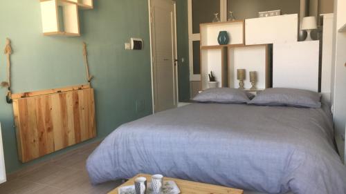 ein Schlafzimmer mit einem großen Bett und einem Holztisch in der Unterkunft Charmant studio à Sfax in Sfax