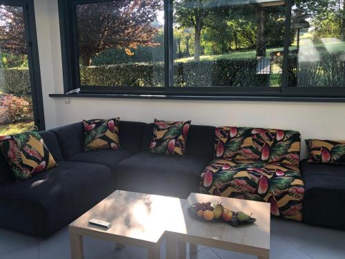 a living room with a couch and a table at Havre de paix et de verdure proche Walibi et A43 - 4 étoiles in Corbelin