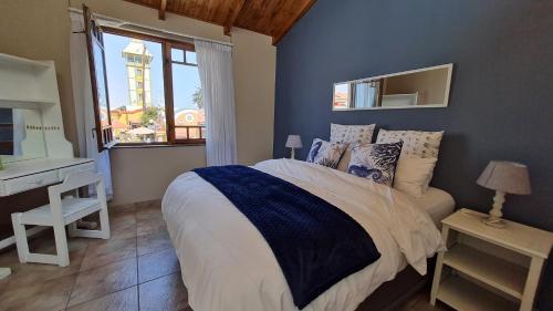 - une chambre avec un lit, un bureau et une fenêtre dans l'établissement Bismarck Swakopmund, à Swakopmund