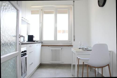 uma cozinha com mesa e cadeiras e uma janela em New & Modern Apartment with Beautiful Lake View! em Lugano