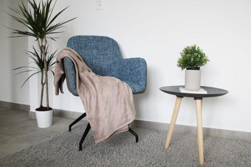 a blue chair with a blanket on it next to a table at New & Modern Apartment with Beautiful Lake View! in Lugano