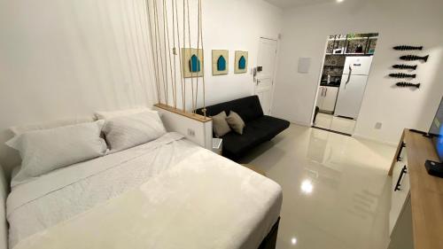 サントスにあるStudio moderno na avenida da praia - Boqueirãoの白いリビングルーム(ベッド1台、ソファ付)
