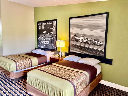 una camera d'albergo con due letti e una foto di una macchina sul muro di Super 8 by Wyndham Rocky Mount I-95 EXIT 145 a Battleboro
