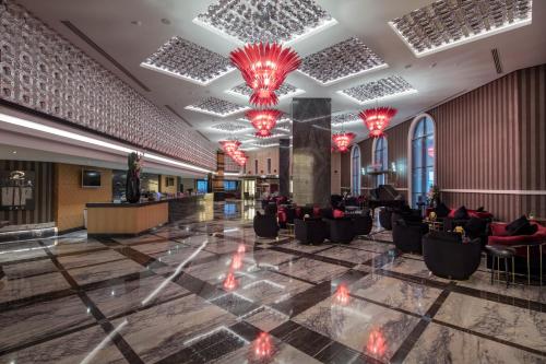 a lobby with red chandeliers and black chairs at Granada Luxury Belek - Family Kids Concept in Belek
