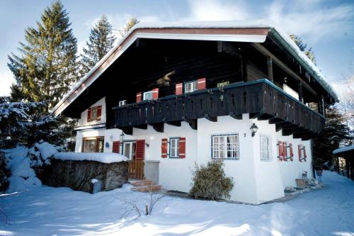 a white house with a balcony in the snow at Beautiful cosy House near Königsee in Schönau am Königssee
