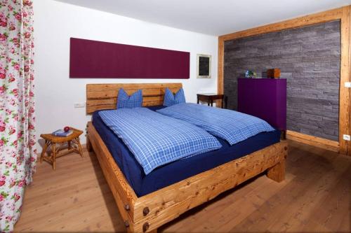 a bedroom with a large wooden bed with blue sheets at Beautiful cosy House near Königsee in Schönau am Königssee