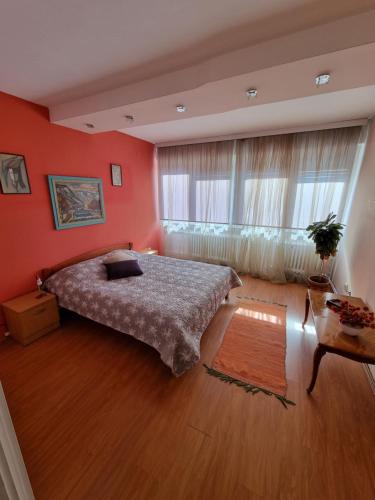 a bedroom with red walls and a bed in a room at Large, Spacious Apartment Voždovac in Belgrade